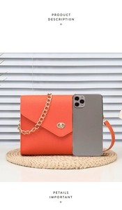 Orange leather crossbody bag with gold lock and chain showing size via smartphone