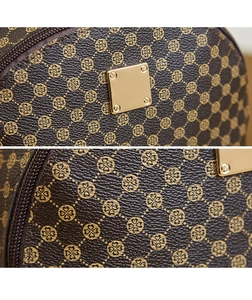 Detail of classic patterned brown leather bag with golden metal logo plate and zip texture