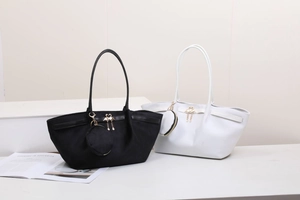 Deux sacs cabas en noir et blanc avec breloques cygne et porte-monnaie sur un podium