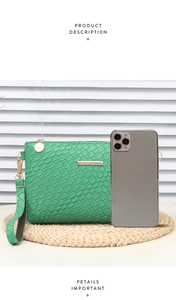 Detailed view of green woven envelope bag size compared to a smartphone