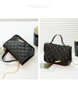 Detail of black quilted leather handbag with gold metal clasp and chain strap