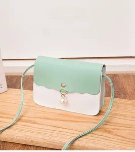 Détail du sac bandoulière vert menthe avec rabat festonné et breloque perle