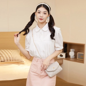Women's quilted chain bag in grey paired with a sweet lace shirt and pink mini skirt