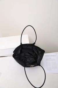 Vue de dessus montrant l'intérieur noir spacieux du sac cabas et détails dorés