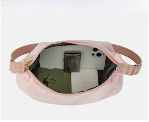 Top view of pink suede underarm bag showing interior capacity with phone and wallet