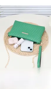 Green woven mini bag detail showing interior storage for phone and accessories