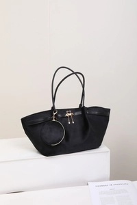 Détail du sac cabas en daim noir avec pendentif cygne doré et petit porte-monnaie rond