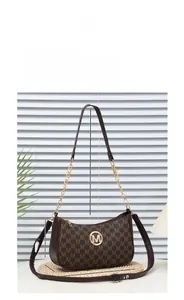 Detail of vintage brown shoulder bag with monogram texture and golden metal logo