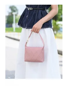 Rosa gesteppte Handtasche mit Goldbeschlägen in einer modischen Streetstyle-Außenszene