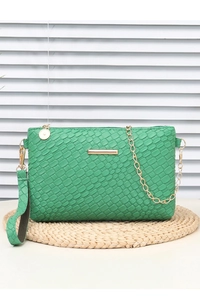 Detailed view of emerald green woven mini bag with gold chain strap and metal bar trim