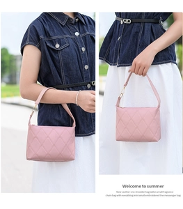 Detail der rosa gesteppten Handtasche mit Textur, Goldbeschlägen und Model am Schulter