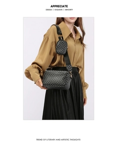 Dettaglio della borsa a tracolla nera monogramma con tracolla larga e astuccio rotondo