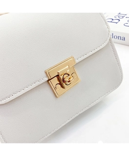 Détail du sac beige en cuir grainé avec fermoir métallique doré et texture chic