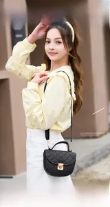 Détails du matelassage et boucle coeur dorée sur un sac à bandoulière vintage noir