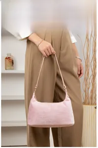 Detailed close-up of pink faux fur baguette bag with soft plush texture and metal rings