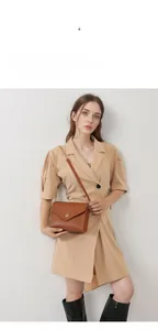 Detail of a brown lychee pattern leather envelope bag with a golden chain strap