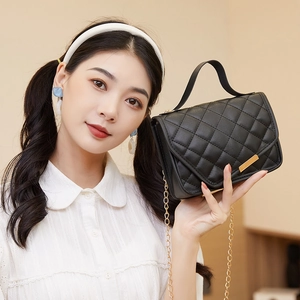 Women's black quilted crossbody bag with gold chain strap and stylish top handle