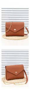 Detail of pink envelope shoulder bag with lychee texture and gold chain strap