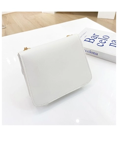 Détail du sac bandoulière blanc minimaliste avec chaîne dorée et texture lisse élégante