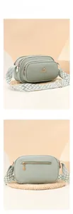Detail of mint green crossbody bag with textured leather and wide woven strap