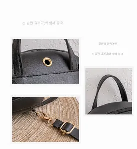 Detail of black pebbled leather mini backpack with golden metal hooks and handle