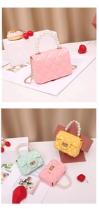 Detail of mini quilted jelly bags with pearl handles and metal chain in candy colors
