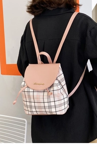 Mini zaino a quadri con patta in pelle rosa e logo in metallo dorato su una modella