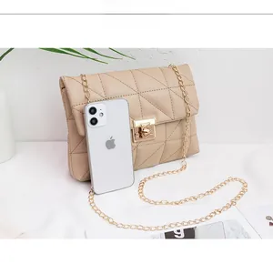 Detail view of beige quilted cloud bag with gold chain strap and metal clasp closure