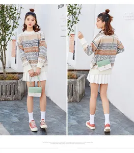 Détail du petit sac bandoulière vert menthe et blanc porté avec un pull en maille géométrique