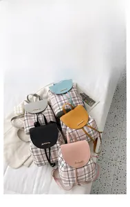 Vista piatta di mini zaini a scacchi nei colori rosa, nero, giallo, grigio e blu