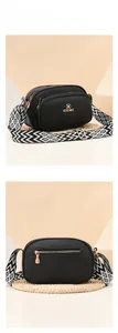 Detail of black pebbled leather crossbody bag with geometric woven strap and zip pockets