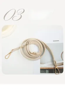 Detail of wide cream woven shoulder strap with gold metal hooks and textured finish