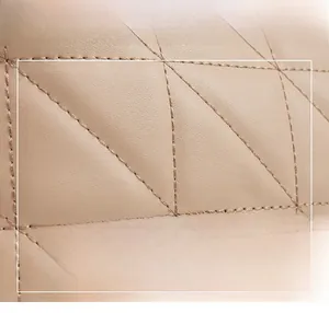 Close-up of beige quilted leather handbag texture with elegant diamond stitching pattern