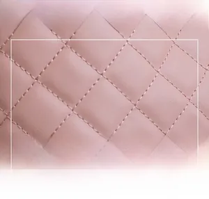 Macro view of light pink quilted diamond stitching on high-quality leather tote bag