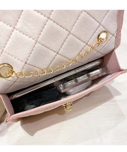 Intérieur du sac matelassé rose montrant le rangement pour téléphone et maquillage