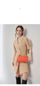 Detail of orange woven texture mini bag with gold chain strap and metal clasp