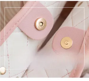 Close-up of golden magnetic snap closures on a pink quilted leather handbag