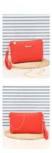 Detail view of pink woven crossbody bag with golden chain strap and wristlet handle