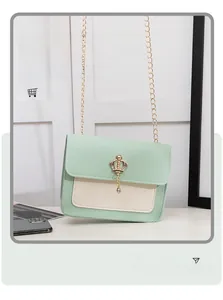 Détail du sac bandoulière vert menthe avec pendentif couronne dorée et fine chaîne