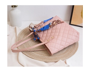 Close-up of pink quilted tote bag featuring an elegant silk scarf wrap on handle