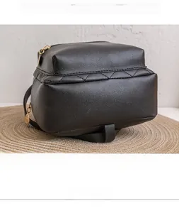 Detailed bottom view of mini black quilted backpack on a circular woven mat