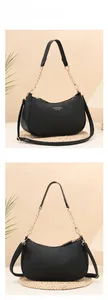 Detail of black pebbled leather hobo bag with gold chain strap and metal zipper