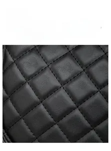 Gros plan sur la texture du cuir noir matelassé avec surpiqûres en losanges de haute qualité
