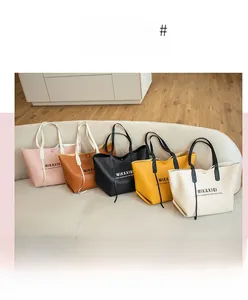 Détails de cinq sacs cabas colorés en plusieurs nuances sur un canapé beige doux