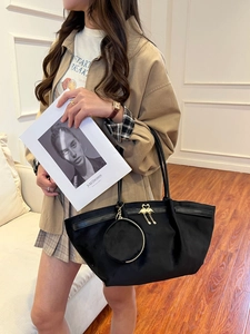 Détail du sac cabas noir avec fermoir cygne doré et petit porte-monnaie assorti