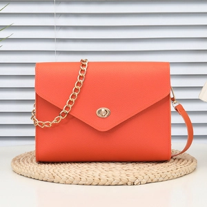 Bright orange pebble leather flap bag with gold twist lock and double shoulder straps