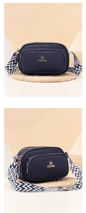 Detail of navy blue lychee grain leather bag with wave pattern woven strap and gold logo