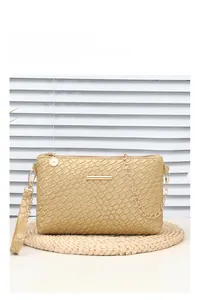 Detailed view of pink woven crossbody bag with gold chain strap on a natural mat