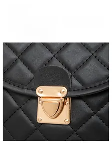 Détail de la boucle en métal doré et de la texture en cuir matelassé du sac noir