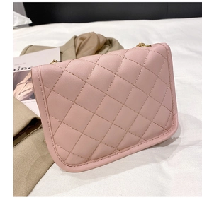 Détail du sac en cuir matelassé rose avec élégante bandoulière en chaîne dorée et coutures